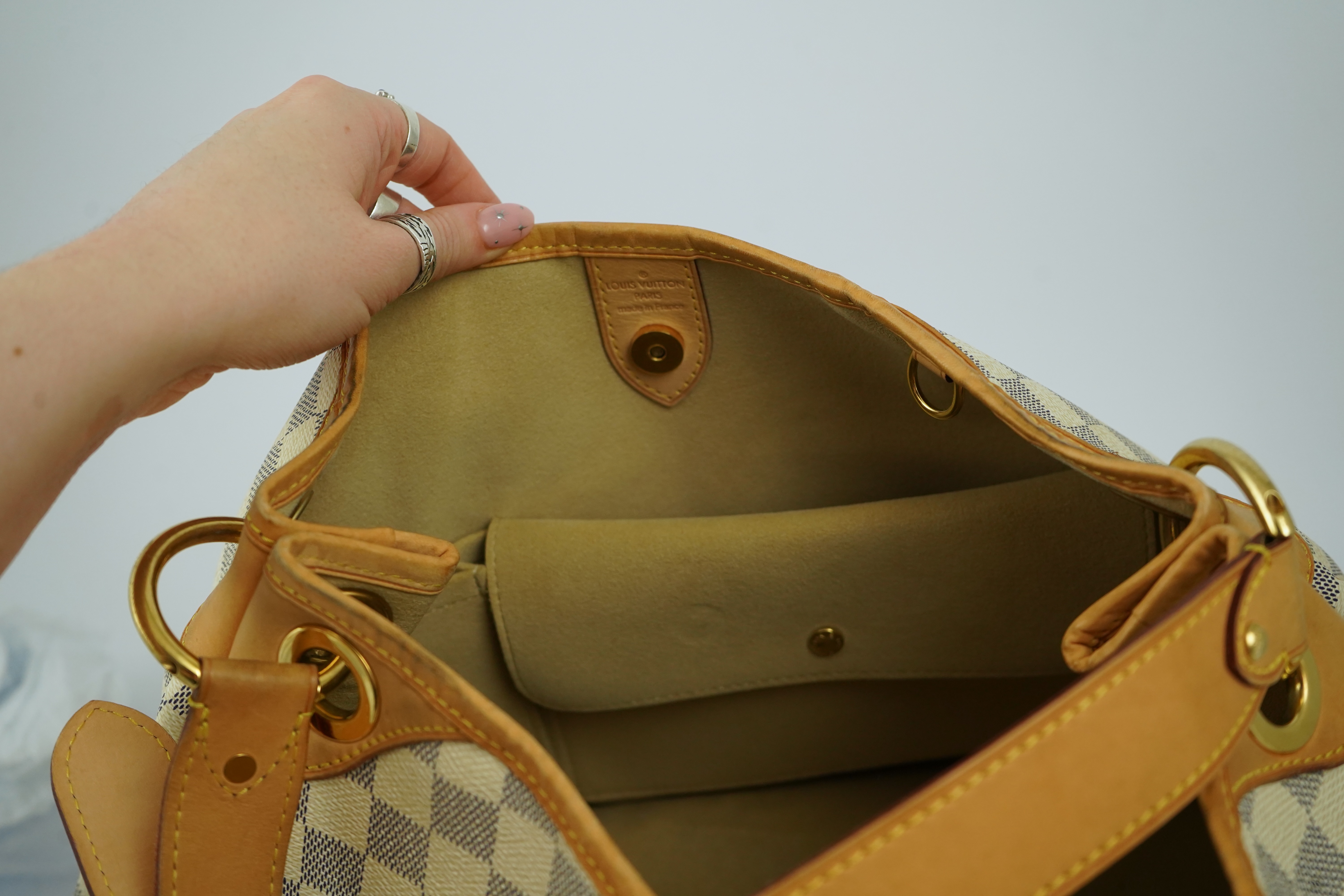 A Louis Vuitton handbag made from Damier Azur canvas with natural cowhide trim